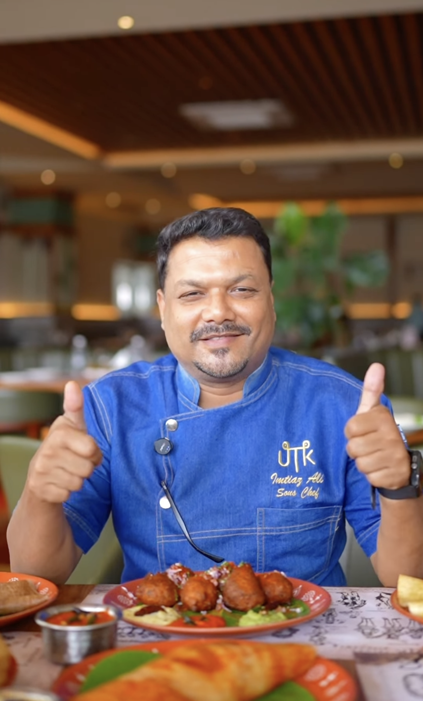 UTK sous chef presenting a dish to the camera